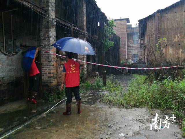 黨群志愿者冒雨拉起警戒線。